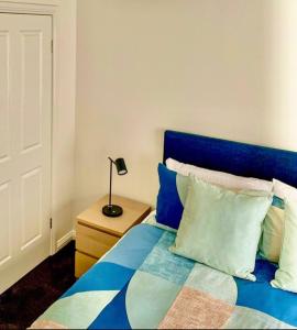 sypialnia z niebieskim łóżkiem z lampką na stoliku nocnym w obiekcie Ballarat CBD Accommodation 2 Bd Townhouse Talbot Terrace w mieście Ballarat