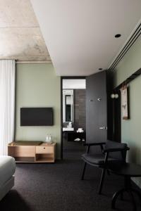 Zimmer mit einem Bett, einem TV und einem Tisch in der Unterkunft Alex Hotel in Perth