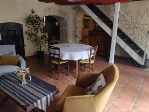 een eetkamer met een tafel en stoelen en een trap bij Le Logis de Lou in Blars
