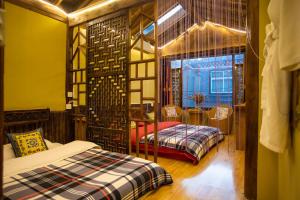 a bedroom with two beds and a table and a window at Shangri-La King Gesar Guesthouse in Shangri-La