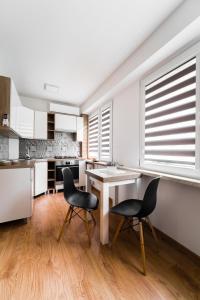 uma cozinha com uma mesa e duas cadeiras em Apartament Paderewskiego 20A em Przemyśl
