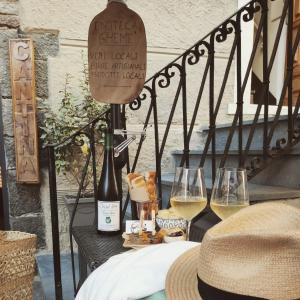 a table with two glasses of wine and a hat at Amore Cove Apartment - Riomaggiore - 5 terre in Riomaggiore