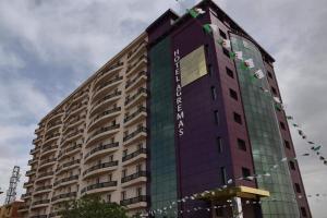 a tall building with a sign on the side of it at Hôtel AGREMAS in Mascara