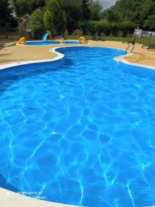 a large swimming pool with blue water at Apartament Dominikana in Sianozety