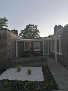 a home with a brick wall and a patio at Rent & Relax in Mol