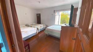 巴納哈契的住宿－Hotel Posada Don Carlos，客房设有两张床、一台电视和一扇窗户。