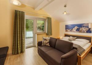 ein Wohnzimmer mit einem Sofa und einem Bett in der Unterkunft Appartements Naturnah in Schladming