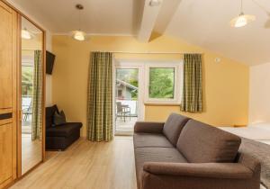 a living room with a couch and a bed at Appartements Naturnah in Schladming