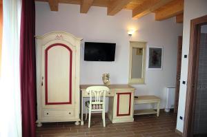Habitación con mesa y TV en la pared. en Agriturismo Aver, en Villafranca di Verona