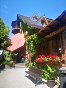 eine Bank, die vor einem Gebäude mit Blumen sitzt in der Unterkunft Hotel Sumski Feneri in Bitola