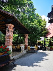 een patio met een tafel en stoelen en een bakstenen paviljoen bij Hotel Sumski Feneri in Bitola