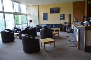 a waiting room with couches and chairs and a table at Hôtel la Régie in Briey