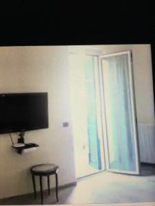 een woonkamer met een televisie en een glazen schuifdeur bij 6alcentrale in Bellagio