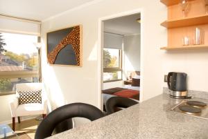 a kitchen with a counter and chairs in a room at Apart Hotel Providencia in Santiago