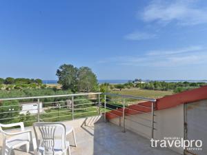 a balcony with chairs and a view of the ocean at Villa Iris by RentalsPro - Agios Mamas Beach in Agios Mamas