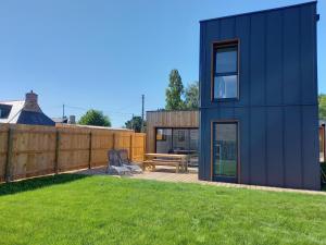 Casa azul con patio trasero con valla de madera en Les Lodges de Beg Leguer - côte de granit rose, en Lannion