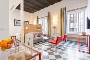 sala de estar con sofá y sillas rojas en Genteel Home San Laureano, en Sevilla