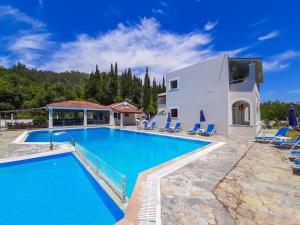 a villa with a swimming pool and a house at Vista Verde Apartments in Sidari