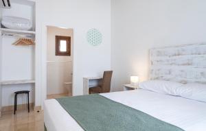 a white bedroom with a bed and a desk at Ad Hoc Vitae Retreats & Health Only Adults in Beniarbeig