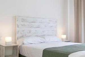 a bedroom with a large white bed with two night stands at Ad Hoc Vitae Retreats & Health Only Adults in Beniarbeig