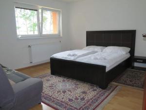 a bed in a room with a rug and a couch at Ubytovňa Kriváň in Važec