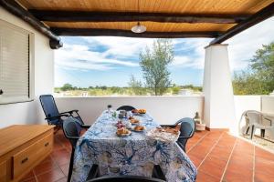 una sala da pranzo con tavolo e sedie su un patio di Villetta Mediterranea a Lotzorai