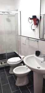 a bathroom with a sink, toilet and mirror at Legend R.G. in Rome
