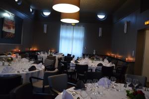 una habitación llena de mesas y sillas con manteles blancos en Hôtel la Régie, en Briey