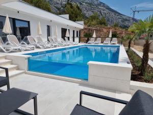 a swimming pool in a villa with chairs at Villa Medak in Makarska