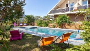 a swimming pool with chairs and a house at Au petit Nice in Brison-Saint-Innocent