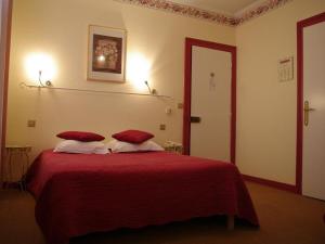 een slaapkamer met een rood bed met 2 kussens bij The Originals Boutique, Hôtel d'Angleterre, Fécamp in Fécamp