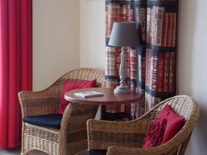 een tafel en twee stoelen met een lamp in een kamer bij The Originals Boutique, Hôtel d'Angleterre, Fécamp in Fécamp