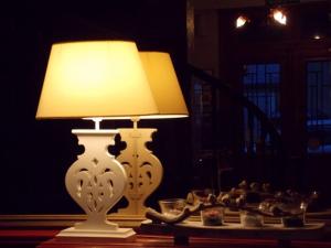 a lamp sitting on a table with a plate of food at The Originals Boutique, Hôtel d'Angleterre, Fécamp in Fécamp