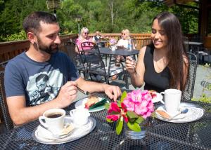 a man and a woman sitting at a table eating food at Waldhotel Ehrental in Schmalkalden