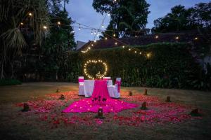 a garden with pink flowers on the ground at night at Samaja Beachside Villas in Seminyak +63 photos
