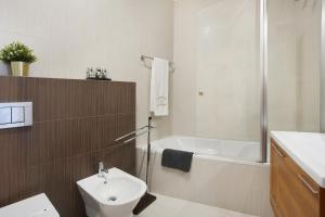 een badkamer met toilet, bad en wastafel bij Villa Rosa Apartment in Portimão +12 foto's