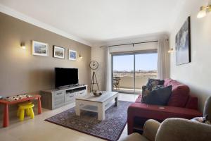 uma sala de estar com um sofá e uma televisão em Villa Rosa Apartment em Portimão