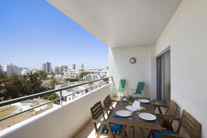 een balkon met tafels en stoelen en uitzicht op de stad bij Villa Rosa Apartment in Portimão