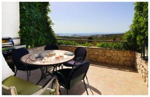 a table and chairs on a patio with a view at Apartment STAR Blažev in Primošten