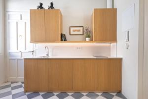 a kitchen with wooden cabinets and a sink at Genteel Home San Laureano in Seville