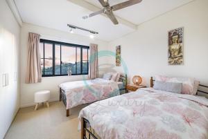 A bed or beds in a room at ZEN PENINSULA - Darwin's Prestigious WaterFront Retreat