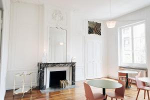 Elle comprend un salon doté de murs blancs et d'une cheminée. dans l'établissement Hotel de Fouquet - Chambres d'hôtes, à Metz