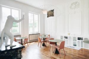 une chambre avec des tables, des chaises et une statue dans l'établissement Hotel de Fouquet - Chambres d'hôtes, à Metz