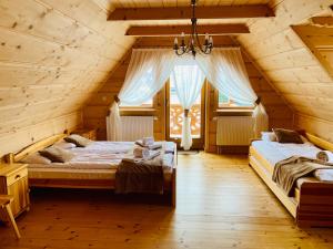 a bedroom with two beds in a log cabin at Dom Pod Bachledówką in Czerwienne