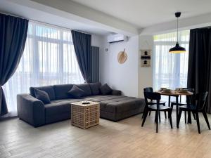 - un salon avec un canapé et une table dans l'établissement Rakish Moon Apartment, à Mamaia Nord – Năvodari