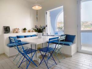 ein Esszimmer mit einem weißen Tisch und blauen Stühlen in der Unterkunft Villa Marisa - La Guarida in Ponza