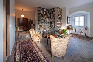 a living room with a table and chairs and a library at Schloß Aichberg in Eichberg