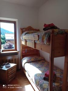 ボルカ・ディ・カドーレにあるTitti house Cortina Dolomitesの窓付きの客室で、二段ベッド2台が備わります。