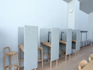 eine Reihe von Tischen und Stühlen in einem Zimmer in der Unterkunft 9h nine hours Hakata station in Fukuoka