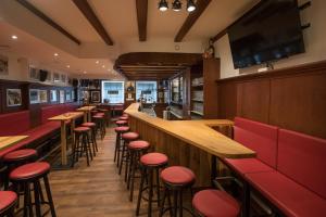 a bar with red stools in a restaurant at Hotel Willinger Mitte in Willingen